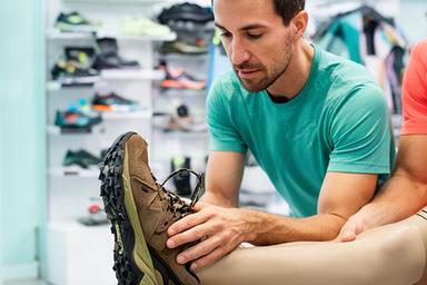 Demolition Chawdry, running coach, checking the fit of a trail shoe in the shop